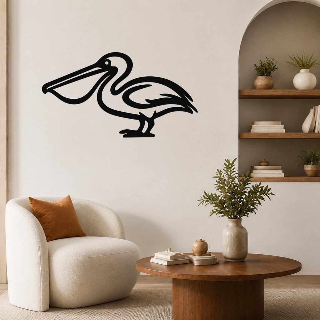 Black metal pelican wall art silhouette mounted on a living room wall above a round wooden coffee table.