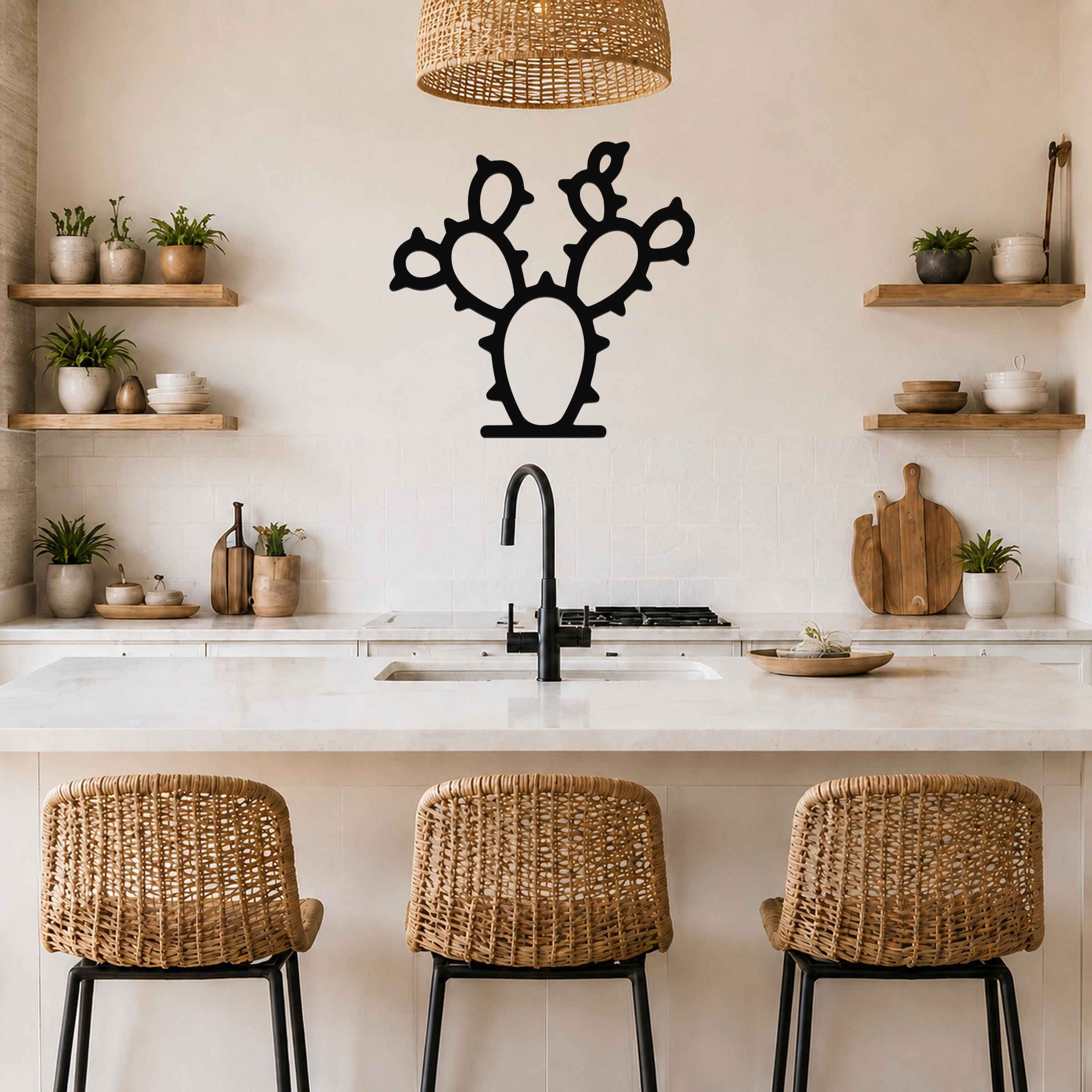 Black metal cactus wall art with a silhouette of a prickly pear, mounted on a kitchen wall above a counter.