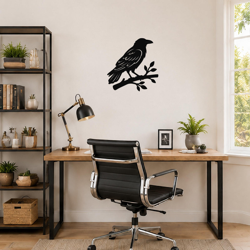 Black metal raven wall art silhouette perched on a branch, mounted above a wooden desk in a home office.