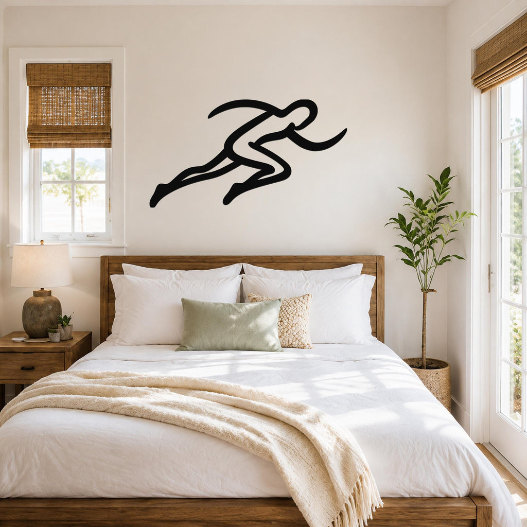 Black metal runner wall art with a dynamic silhouette, mounted above a bed in a bright bedroom.