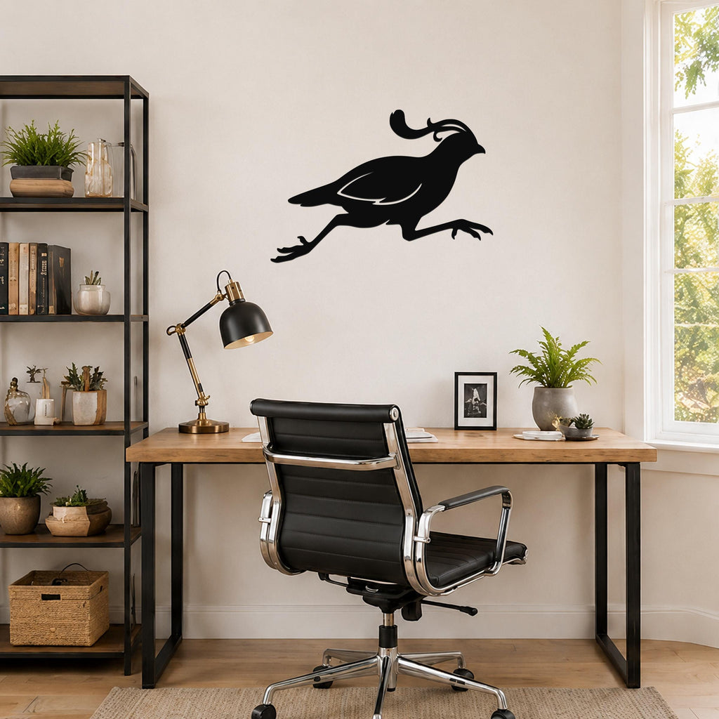 Black metal quail wall art in a running silhouette, mounted on a light-colored wall above a wooden desk in a home office.
