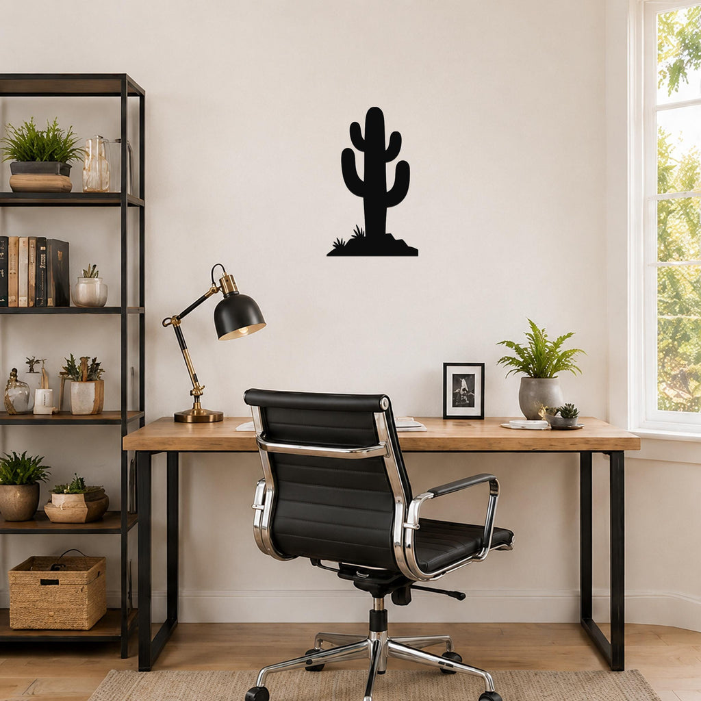 Black metal cactus wall art with a silhouette design, mounted on a wall above a wooden desk in a home office.