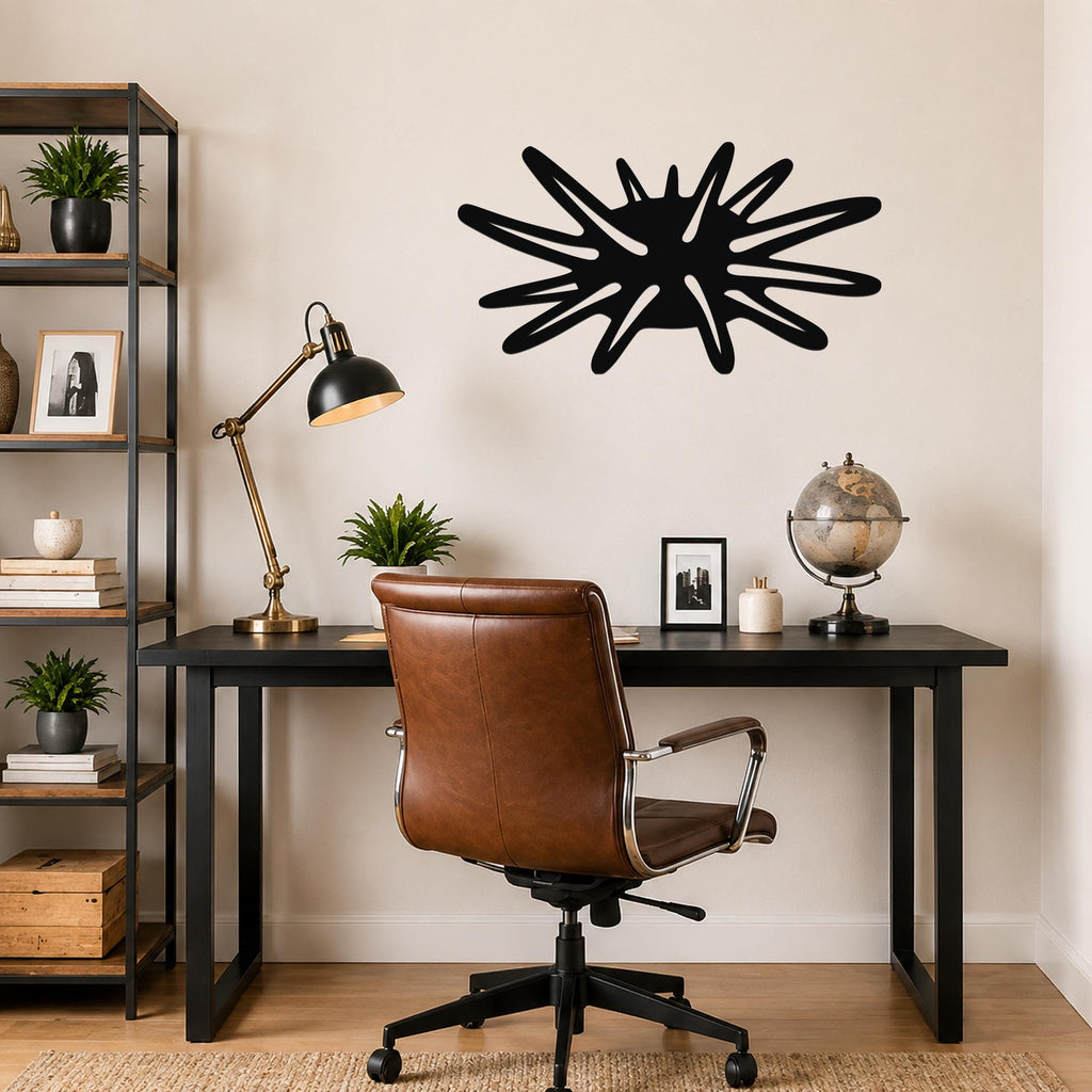 Black metal wall art in a sea urchin silhouette with radiating spines, mounted on a wall above a desk in a home office.