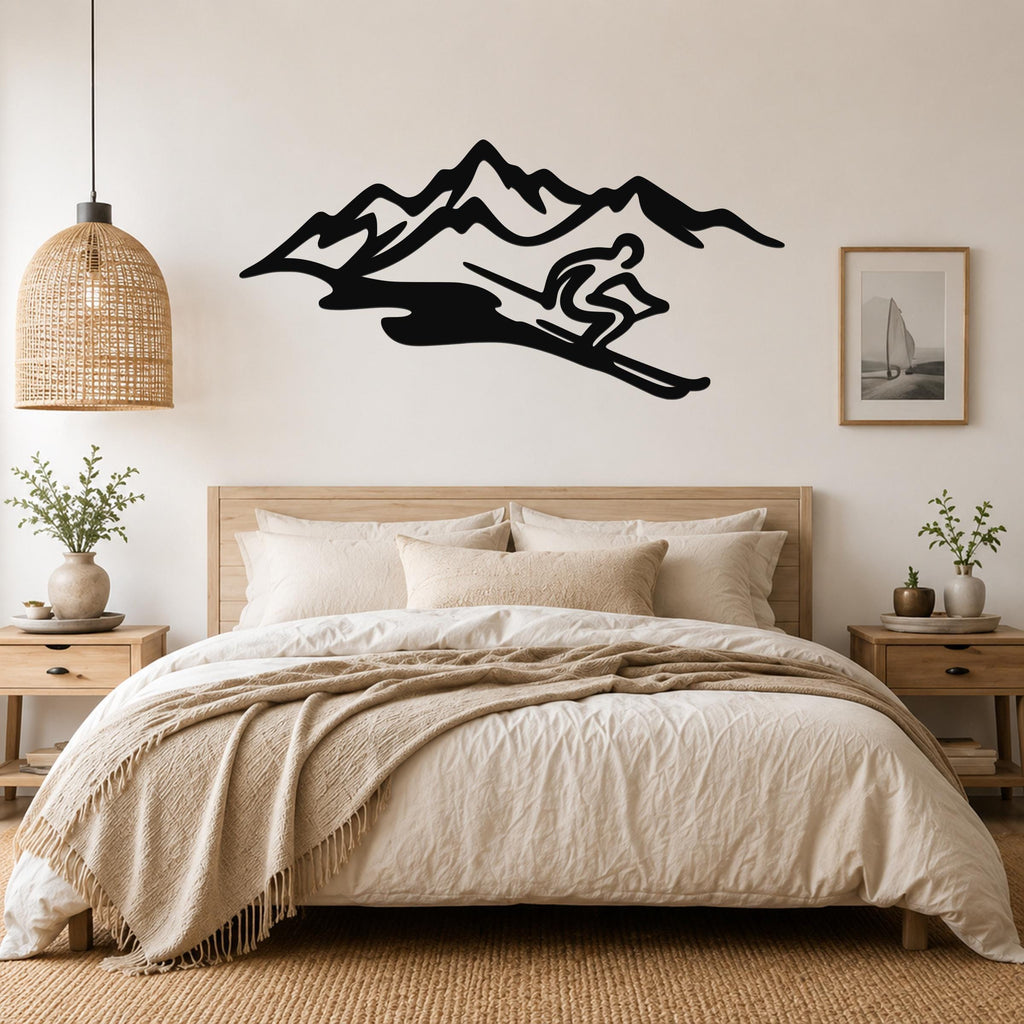 Black metal wall art featuring a skier silhouette descending a mountain range, mounted above a bed in a neutral bedroom.