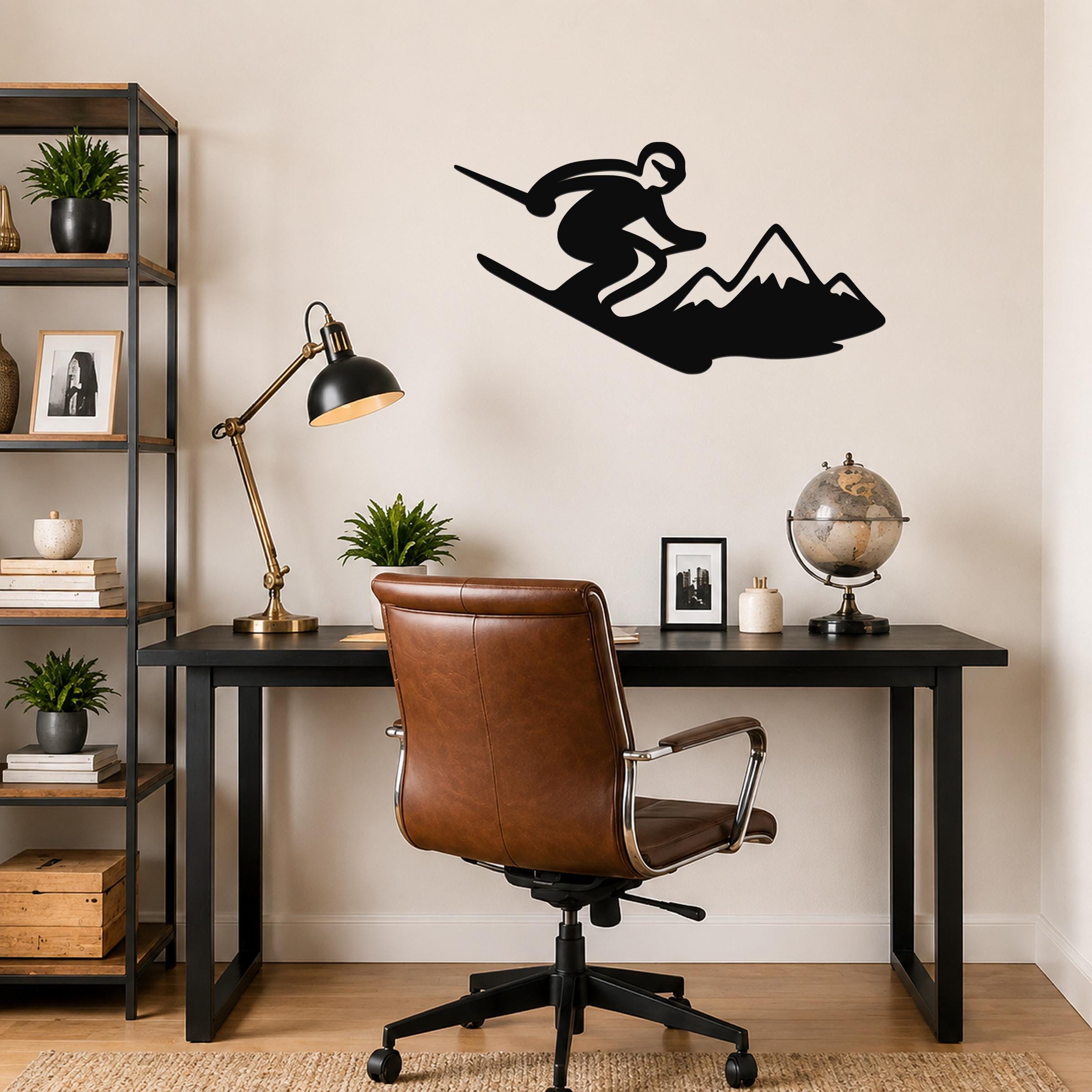 Black metal wall art silhouette of a skier in motion above a mountain, mounted on a wall above a desk in a home office.