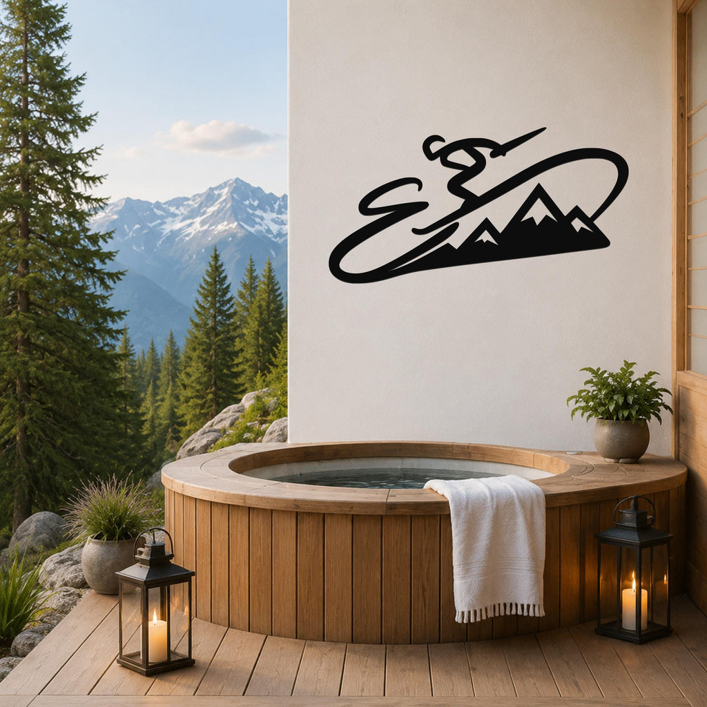 Black metal wall art featuring a skier silhouette and mountain range, mounted on a white wall above a wooden hot tub on a deck with a mountain view.
