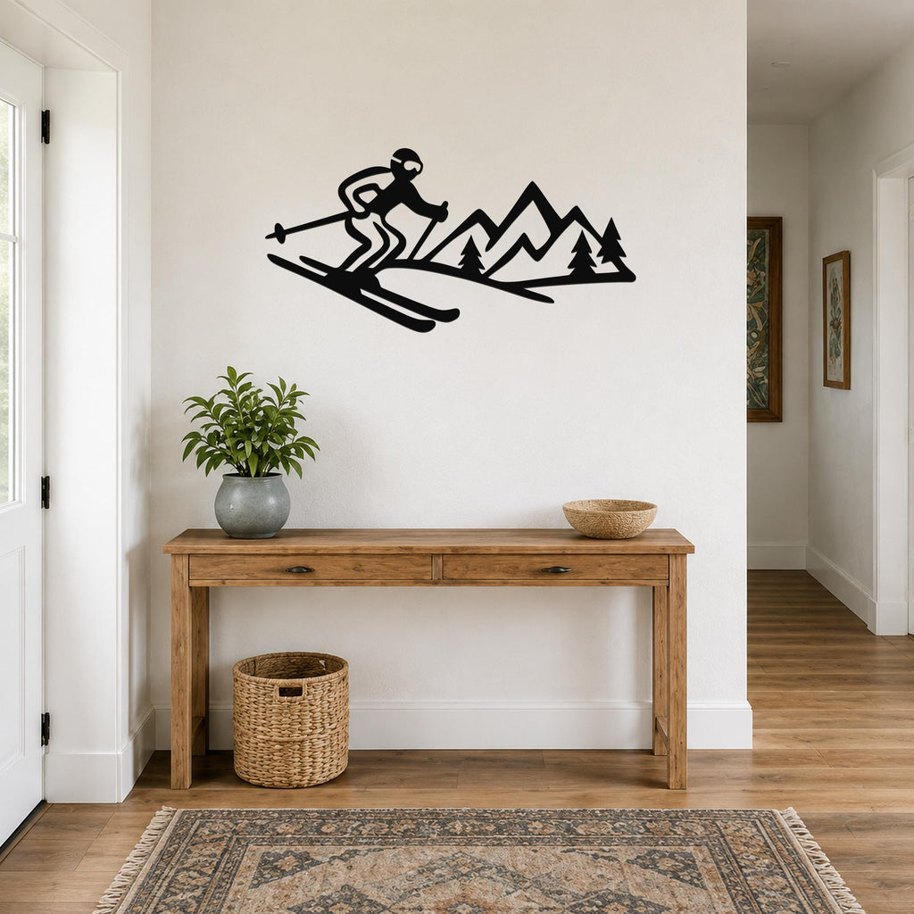 Black metal wall art silhouette of a skier and mountain range, mounted above a wooden console table in a hallway.