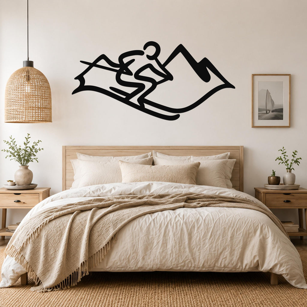 Black metal wall art silhouette of a skier in motion above a bed, mounted on a light-colored bedroom wall.