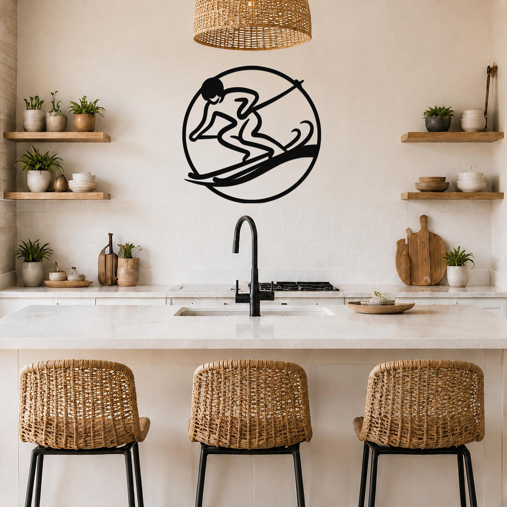 Black metal wall art of a surfer silhouette inside a circle, mounted on a kitchen wall above a counter with wicker bar stools.