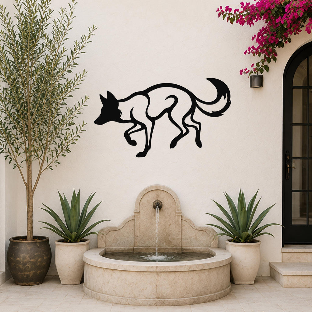 Black metal coyote wall art with a bold silhouette design, mounted on an outdoor patio wall above a stone fountain.