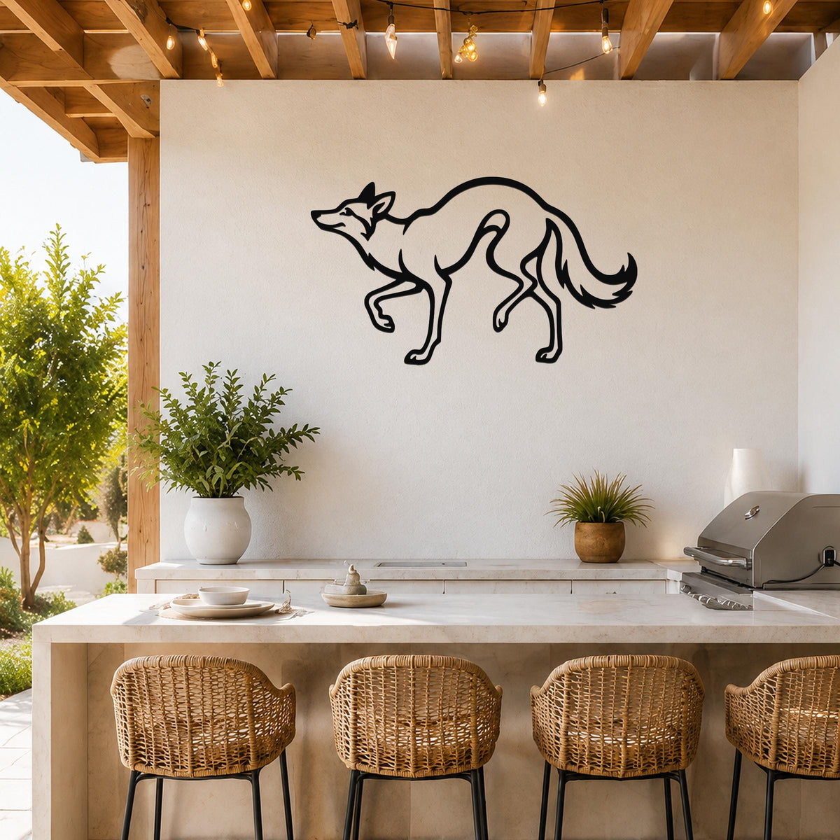 Black metal coyote wall art with a sleek silhouette design, mounted on a white outdoor kitchen wall above a counter with wicker bar stools.