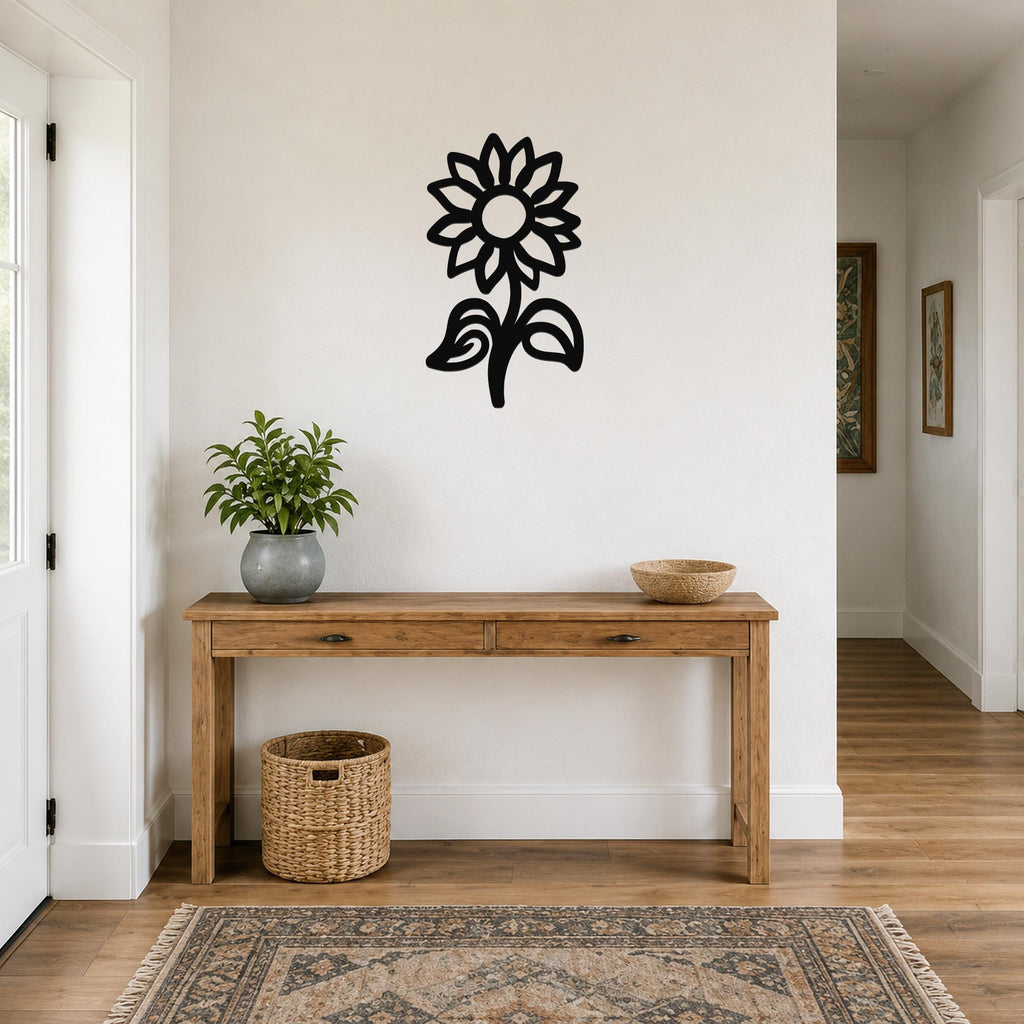 Black metal sunflower wall art with a silhouette design, mounted on a white wall above a wooden console table in a hallway.