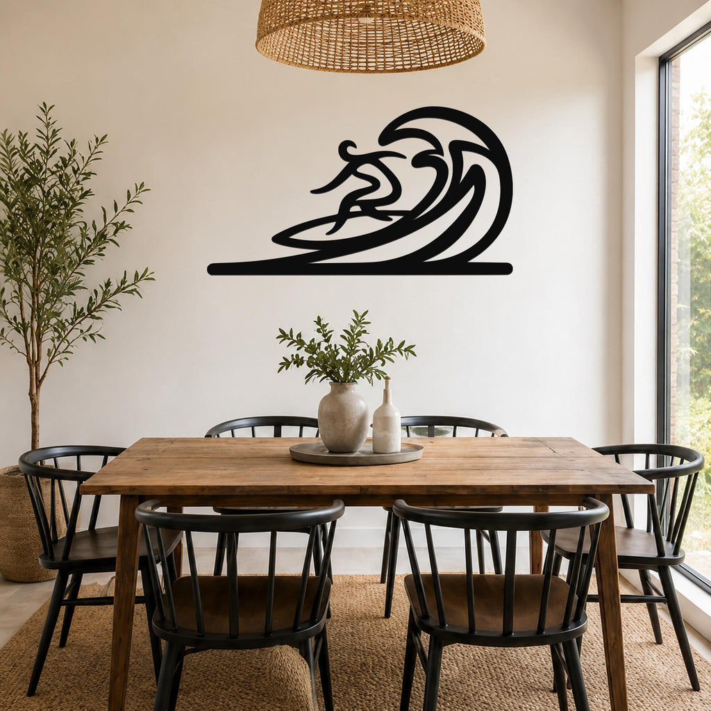 Black metal surfer wall art with flowing wave cutout, mounted on a dining room wall above a wooden table.