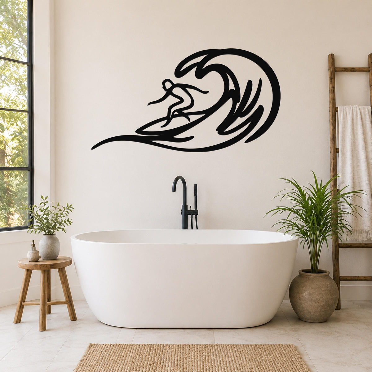 Black metal surfer wall art with wave cutout design, mounted on a bathroom wall above a freestanding tub.