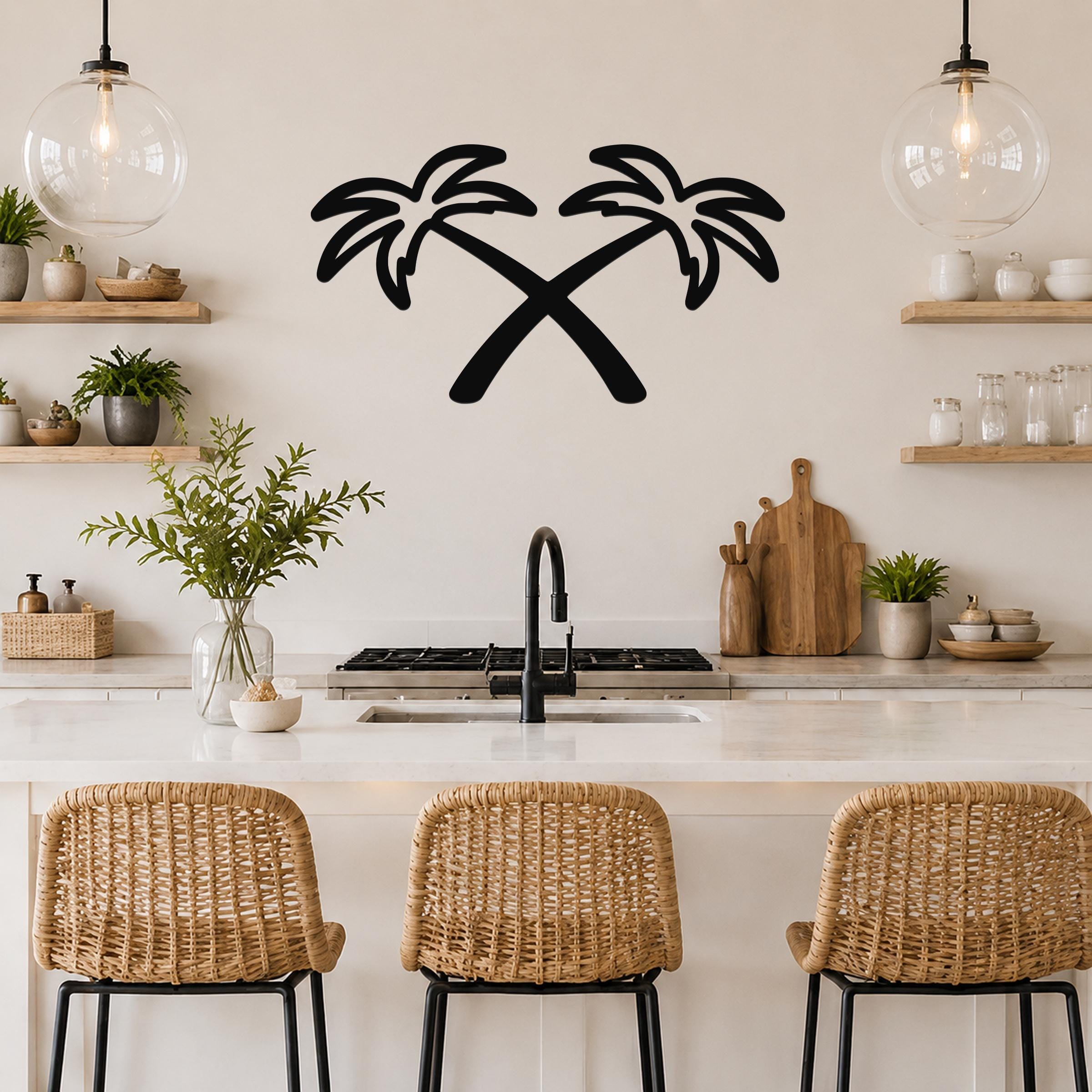 Black metal wall art featuring a silhouette of two crossed palm trees, mounted on a kitchen wall above a counter.
