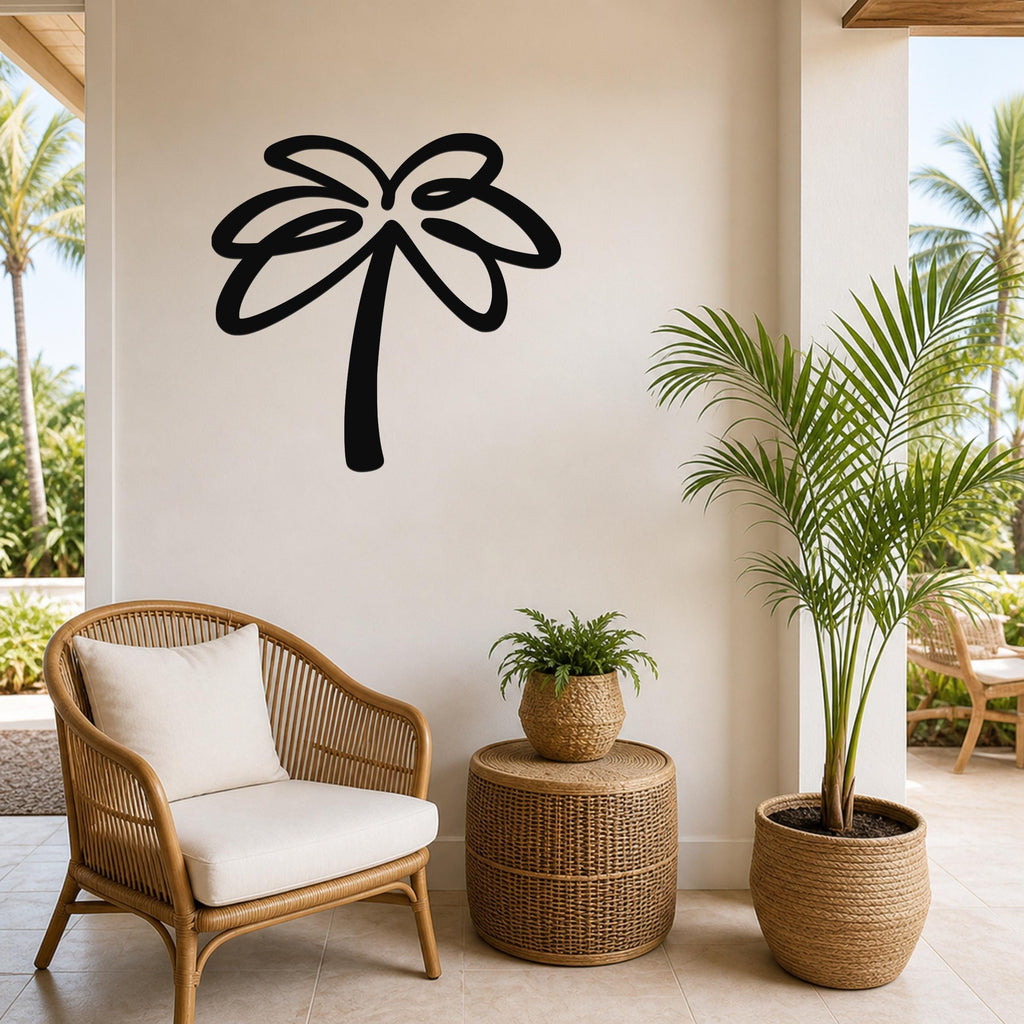Black metal palm tree wall art with flowing frond cutouts, mounted on a beige wall above a wicker chair in a coastal patio setting.
