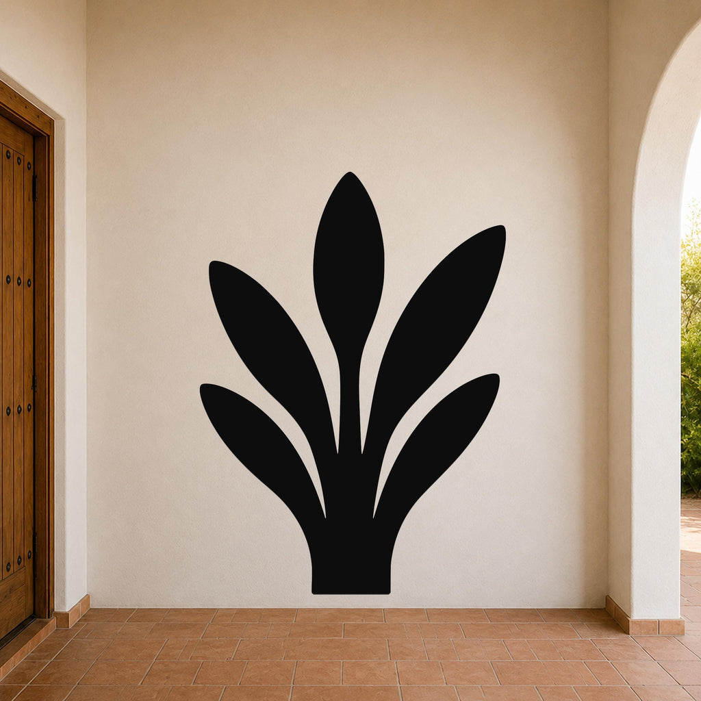 Black metal wall art in a snake plant silhouette, mounted on a beige outdoor wall above terracotta tile flooring.