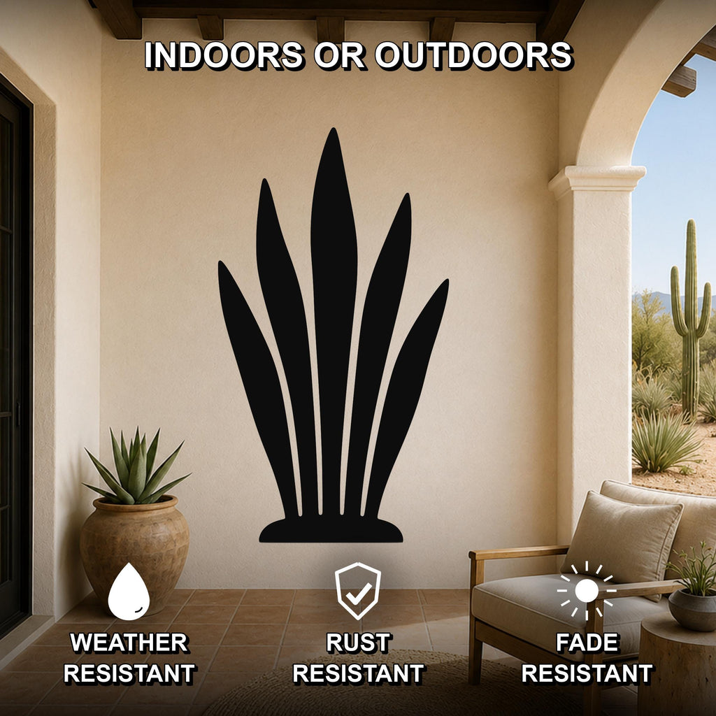 Black metal snake plant wall art silhouette mounted on a beige outdoor patio wall, displayed above a wooden chair with cushions and a potted succulent nearby.