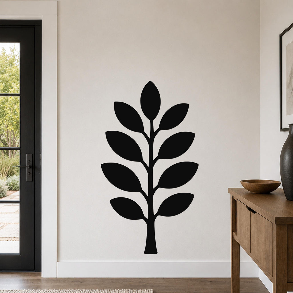 Black metal wall art in a leafy branch silhouette, mounted on a light-colored wall in a modern entryway.