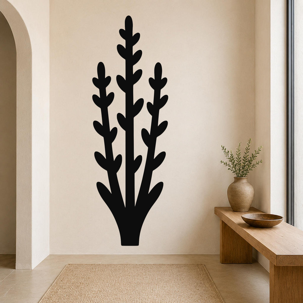 Black metal wall art in a silhouette of an abstract desert plant with three tall stems and leaf cutouts, mounted on a beige wall above a wooden bench in a living room.