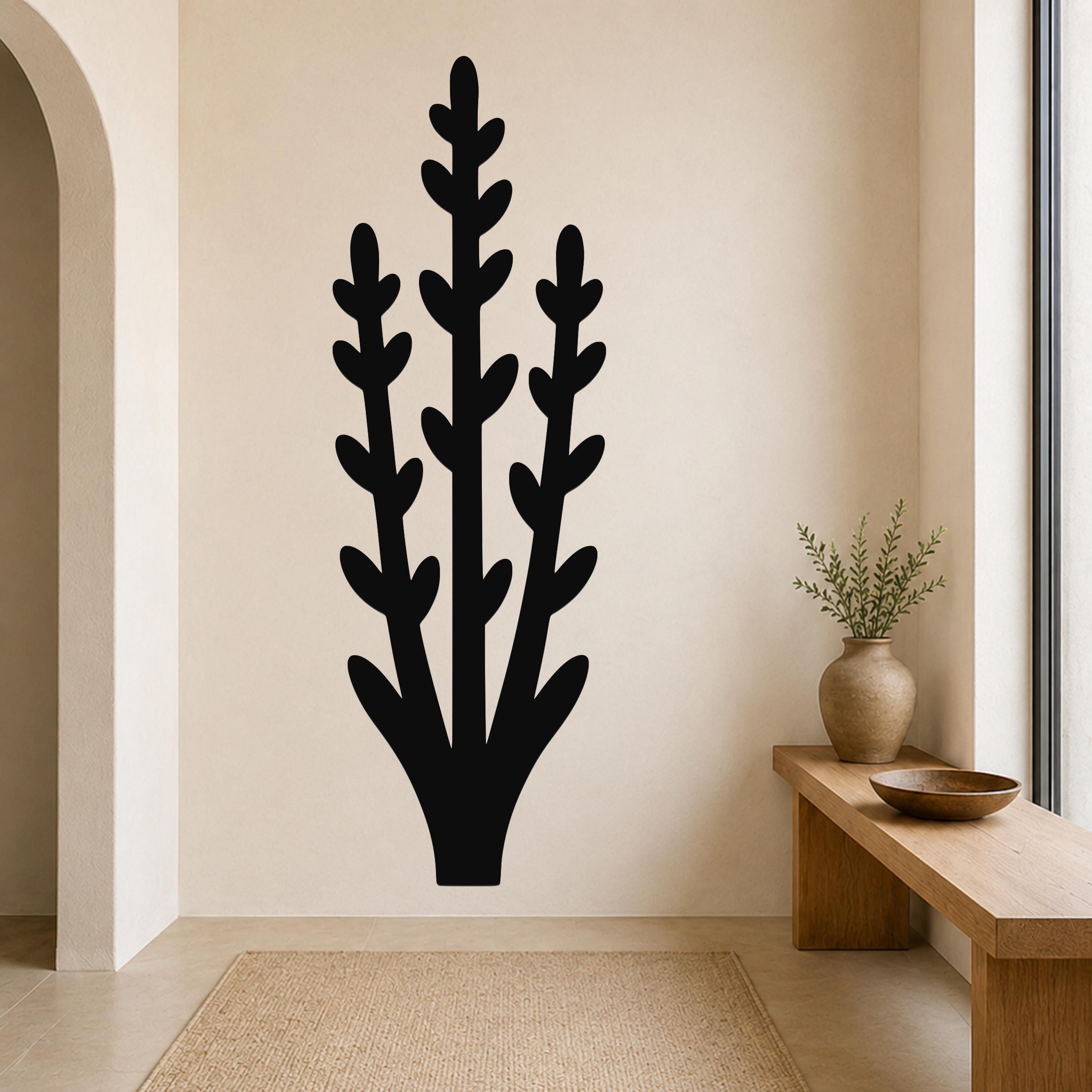 Black metal wall art in a silhouette of an abstract desert plant with three tall stems and leaf cutouts, mounted on a beige wall above a wooden bench in a living room.