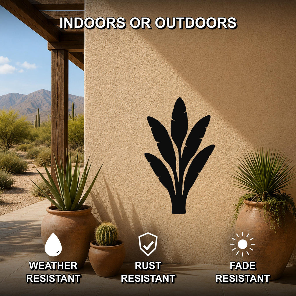Black metal banana plant wall art silhouette mounted on an outdoor patio wall, weather resistant, rust resistant, and fade resistant, with potted plants nearby.
