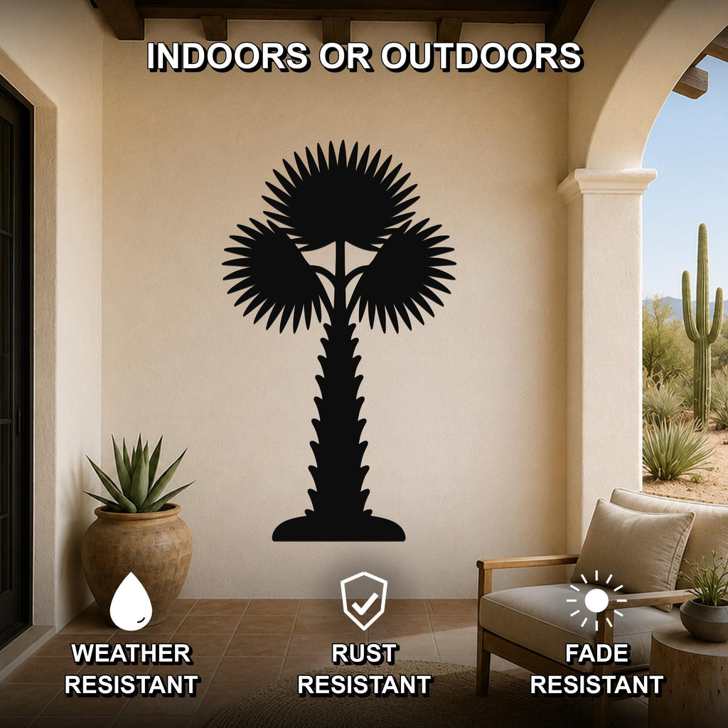 Black metal palm tree wall art with layered frond cutouts, mounted on a beige outdoor patio wall above a wooden chair.