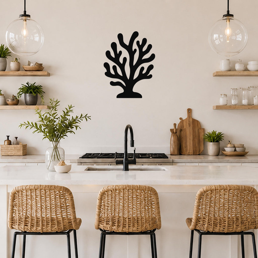 Black metal coral wall art with branching cutouts, mounted on a kitchen wall above a counter between two glass pendant lights.