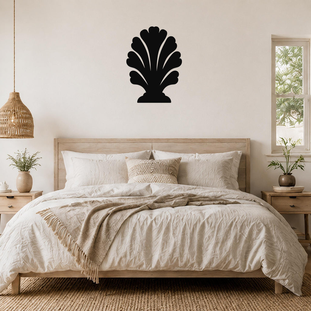 Black metal wall art in a coral or shell silhouette shape, mounted above a bed in a neutral bedroom.