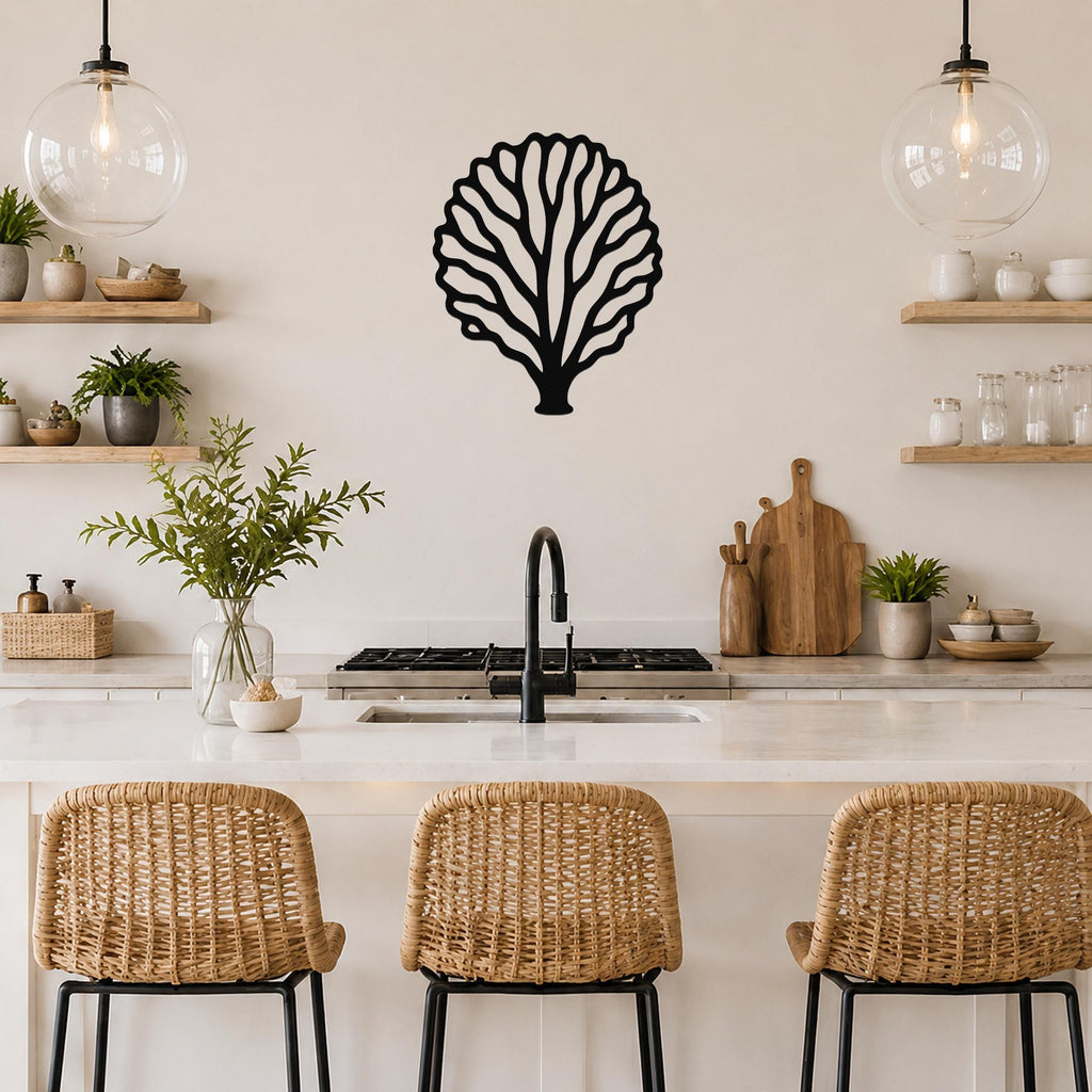 Black metal fan coral wall art with intricate branch cutouts, mounted on a kitchen wall above a white countertop.