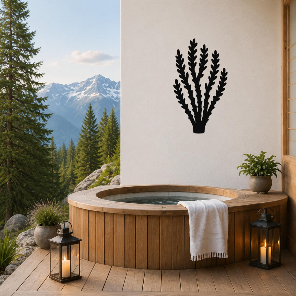 Black metal wall art in a desert branch silhouette, mounted on a white wall above a wooden hot tub on a mountain-view patio.