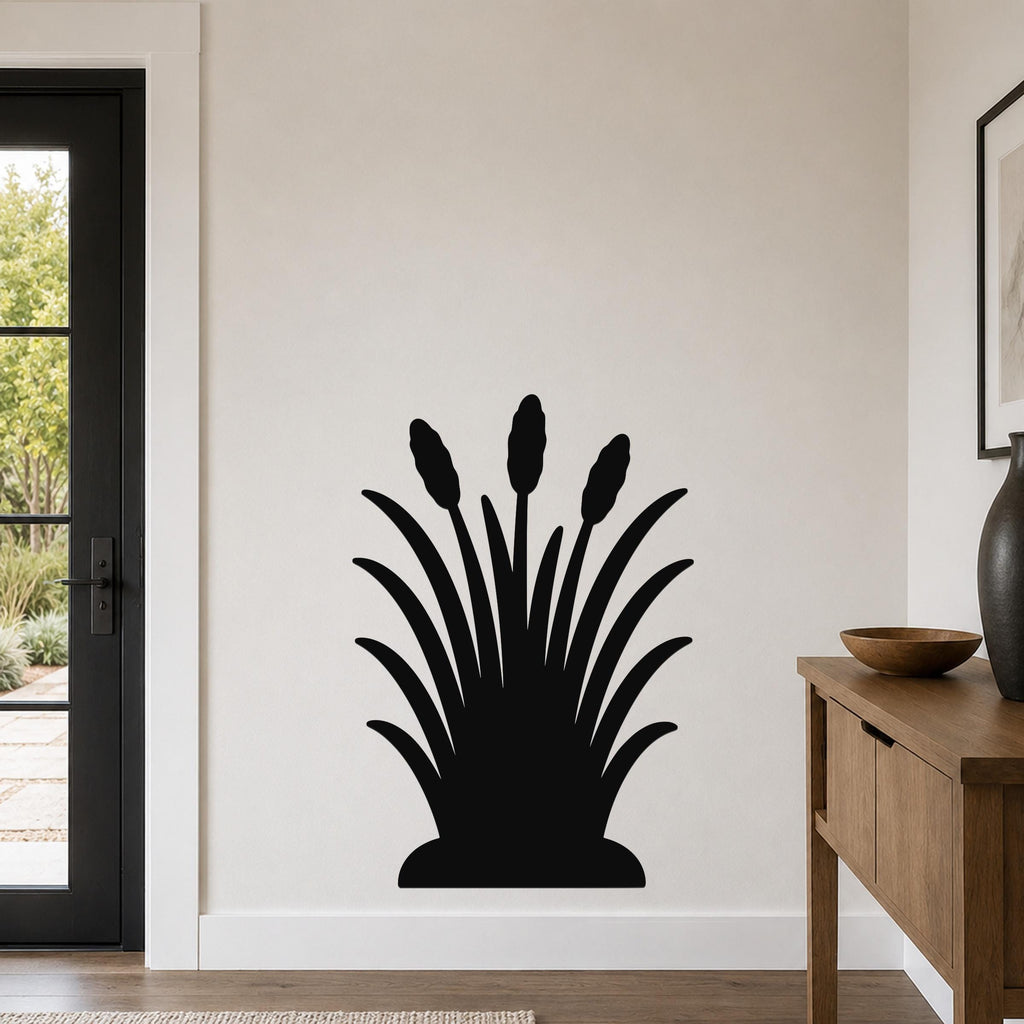 Black metal wall art in a cattail silhouette design, mounted on a white wall in a living room near a door and console table.