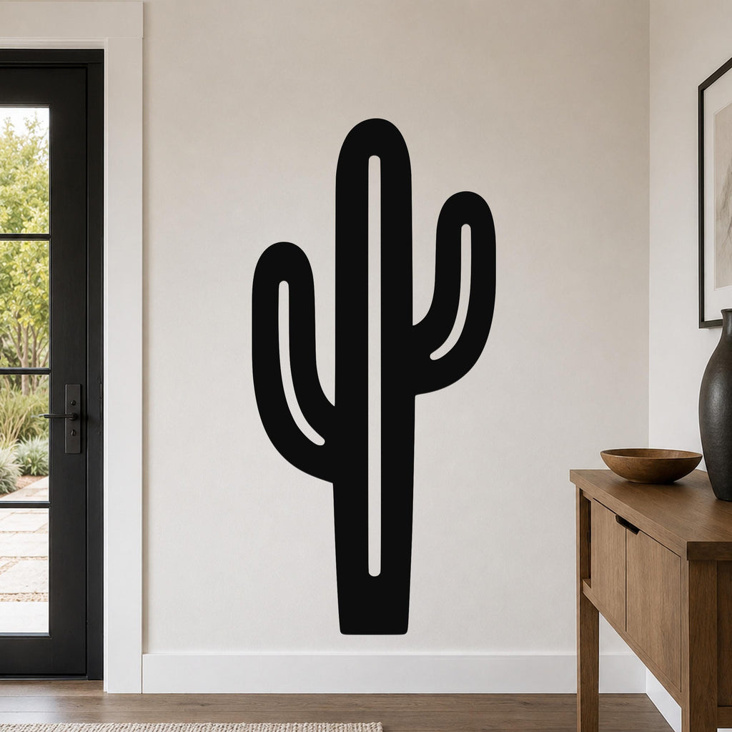 Black metal saguaro cactus wall art with cutout arms, mounted on a living room wall above a wooden console table.