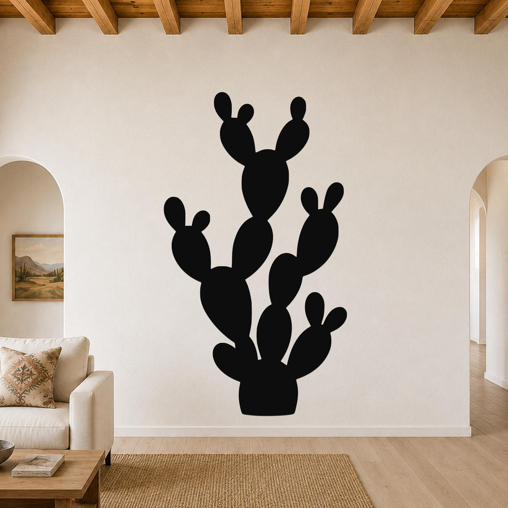 Black metal wall art in the silhouette of a prickly pear cactus, mounted on a living room wall above a sofa.