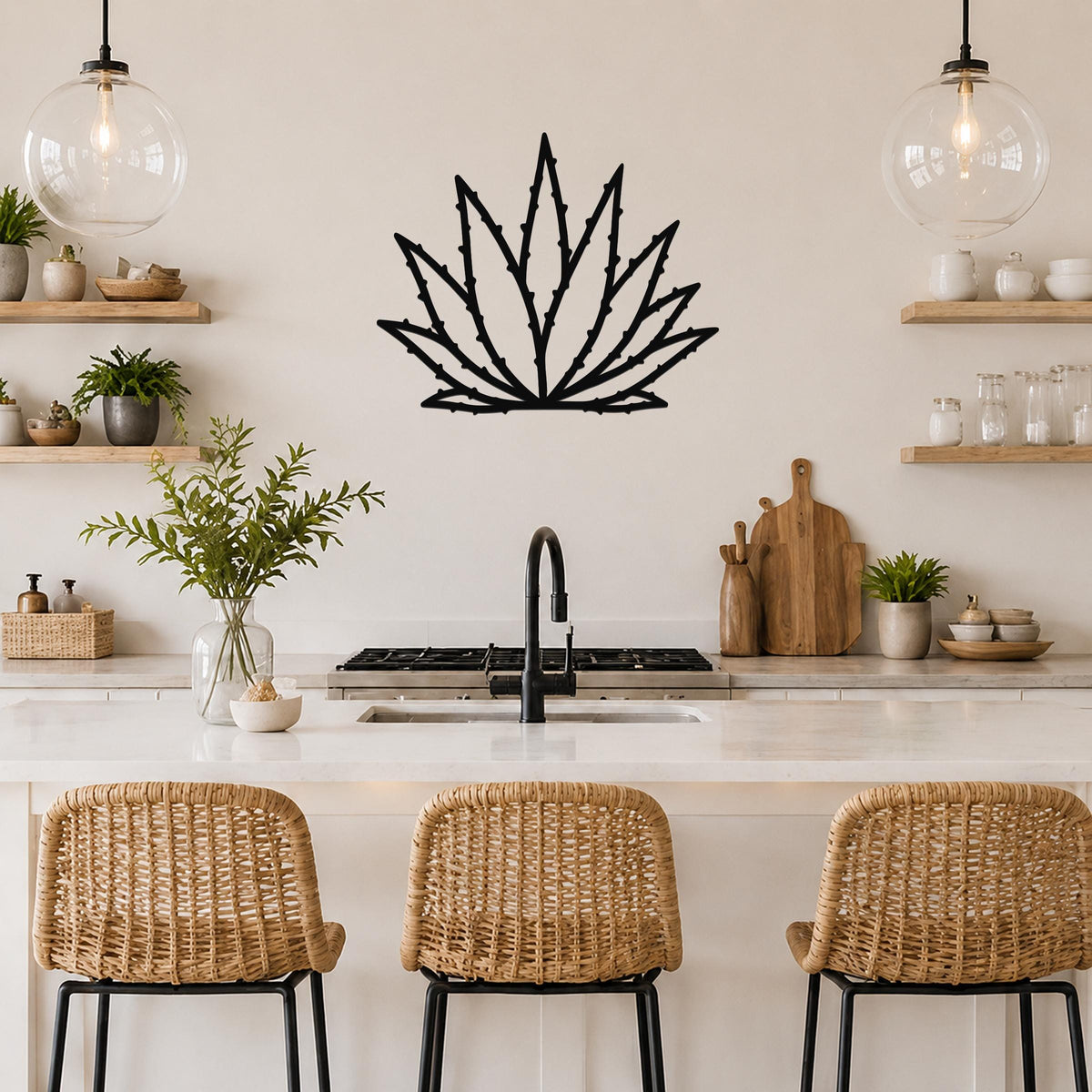 Black metal agave wall art with spiky leaf cutouts, mounted on a kitchen wall above a counter with wicker bar stools.