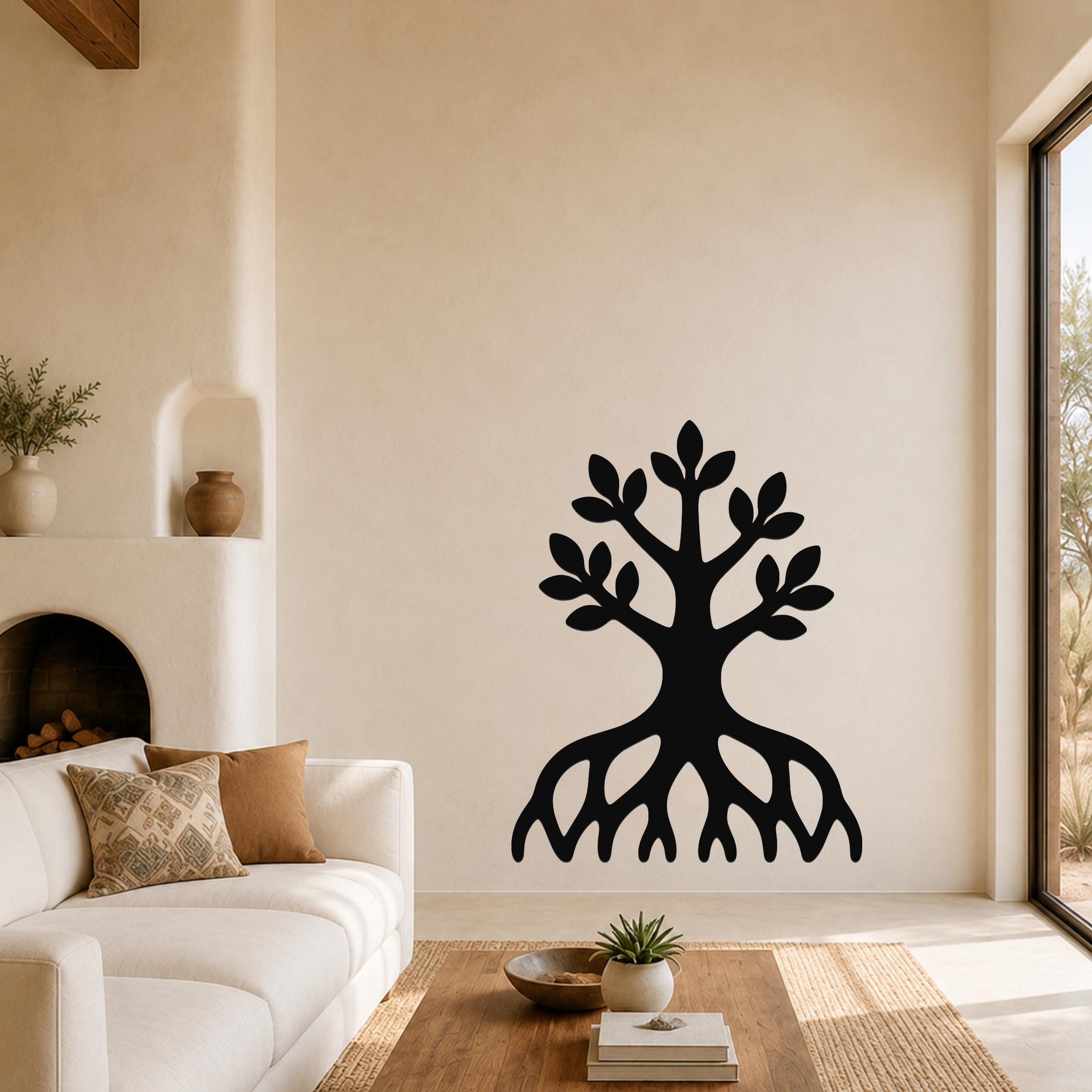 Black metal wall art in the shape of a tree with visible roots and leafy branches, mounted on a living room wall above a sofa.