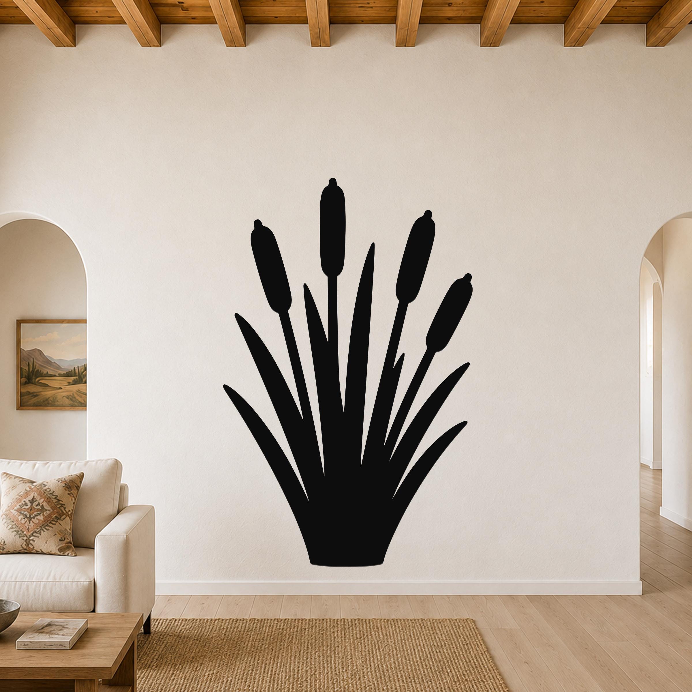 Black metal cattail wall art silhouette with tall reeds and seed heads, mounted on a living room wall above a sofa.