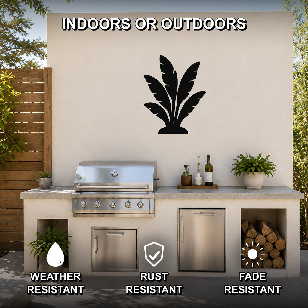 Black metal tropical leaves wall art silhouette mounted on an outdoor patio wall above a stainless steel grill and countertop.