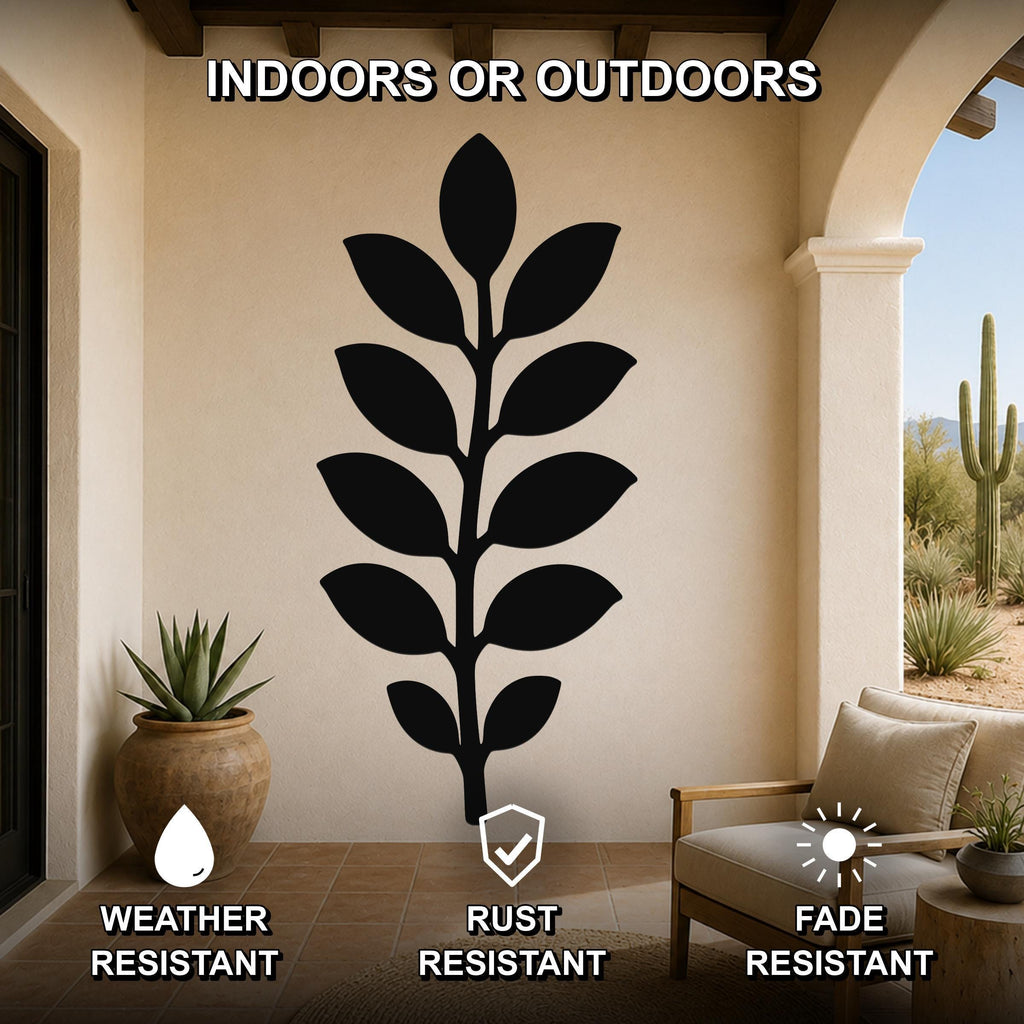 Black metal leaf wall art with a silhouette design, mounted on a beige outdoor patio wall above a chair and potted plant.