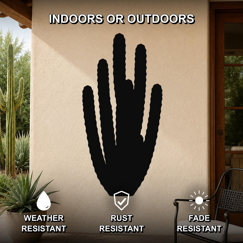 Black metal organ pipe cactus wall art with vertical ribbed cutouts, mounted on an outdoor patio wall above a potted plant.