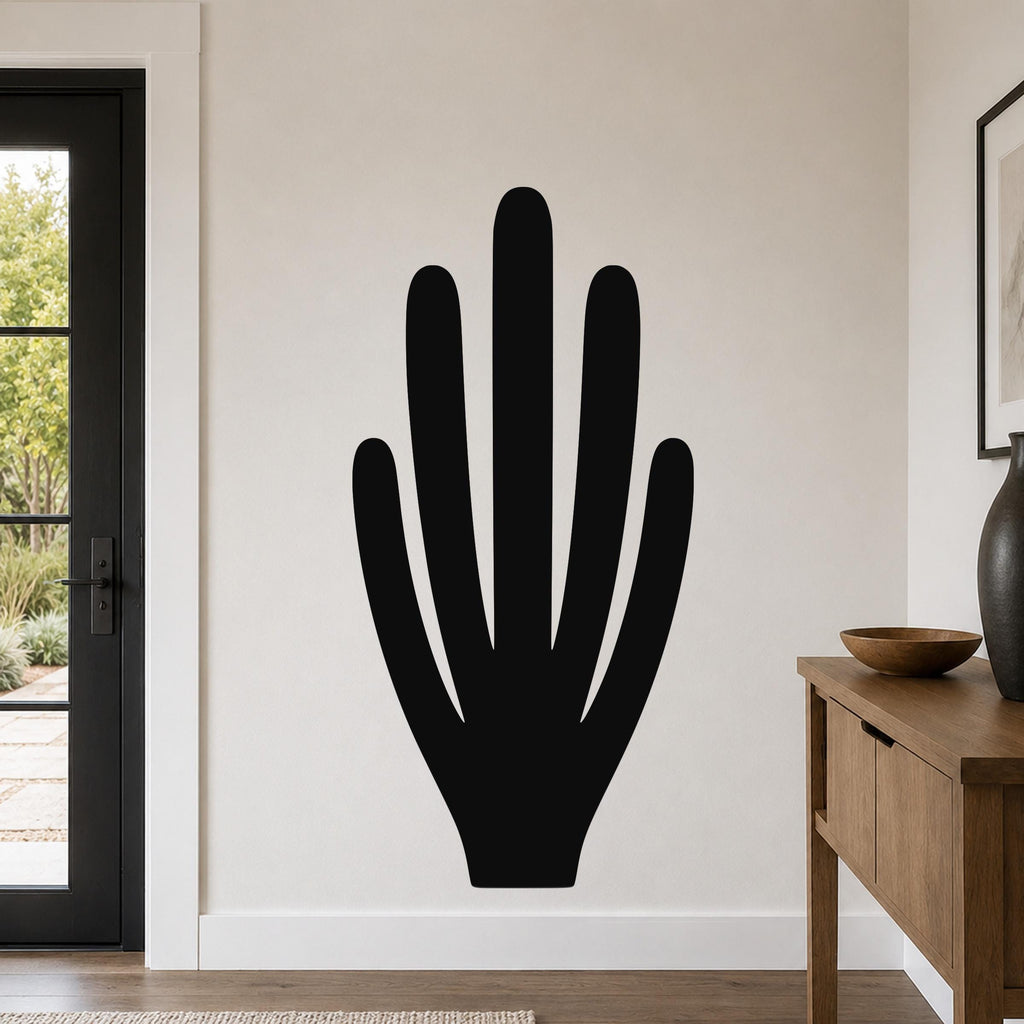 Black metal wall art in the shape of an organ pipe cactus, mounted on a white wall in a living room near a door and console table.