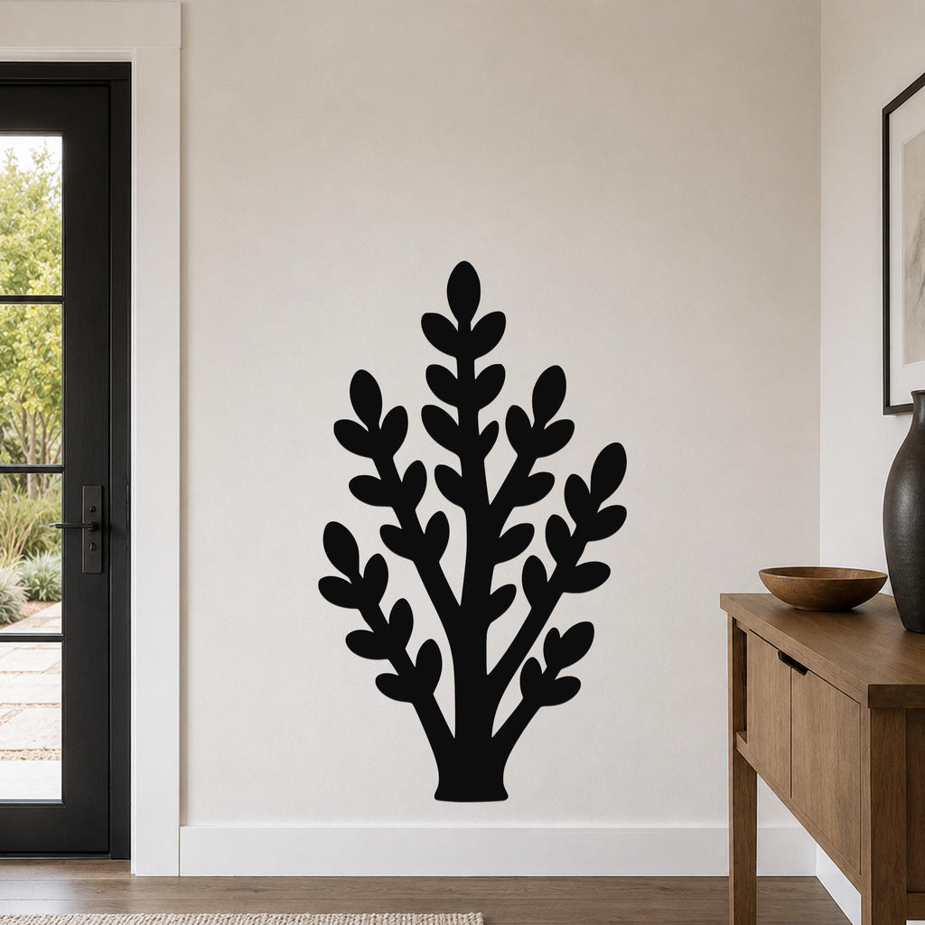 Black metal wall art in a silhouette of a jade plant with layered leaf cutouts, mounted on a light-colored wall in a modern entryway.