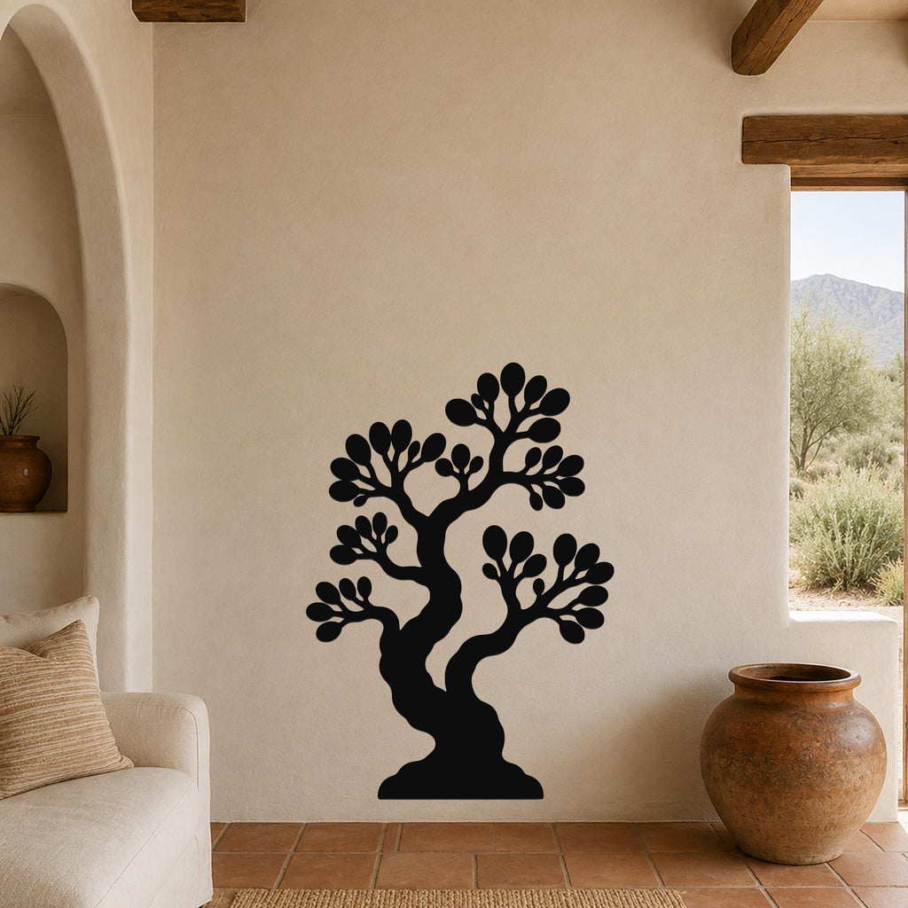Black metal wall art of a bonsai tree with layered branches and leaf cutouts, mounted on a beige wall above a sofa in a living room.