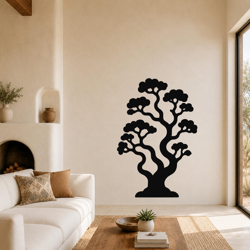 Black metal bonsai tree wall art with layered branches and foliage cutouts, mounted on a living room wall above a sofa.