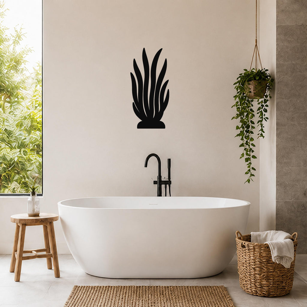 Black metal kelp wall art silhouette mounted on a beige bathroom wall above a freestanding tub.