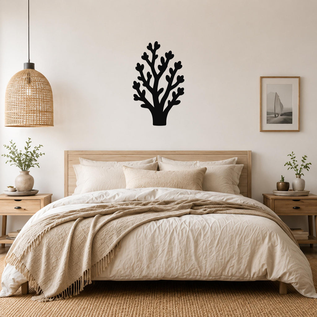 Black metal wall art in a tree silhouette with branching cutouts, mounted above a wooden bed in a neutral bedroom.