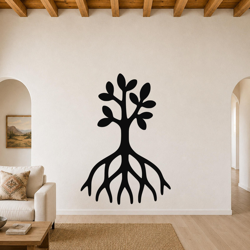 Black metal wall art in the shape of a tree with visible roots and leafy branches, mounted on a living room wall above a sofa.