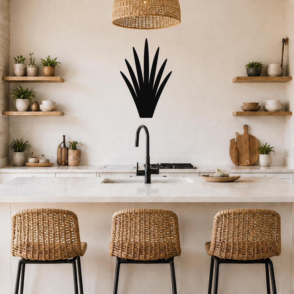 Black metal yucca wall art silhouette mounted on a kitchen wall above a counter, with wicker bar stools and open shelves visible below.