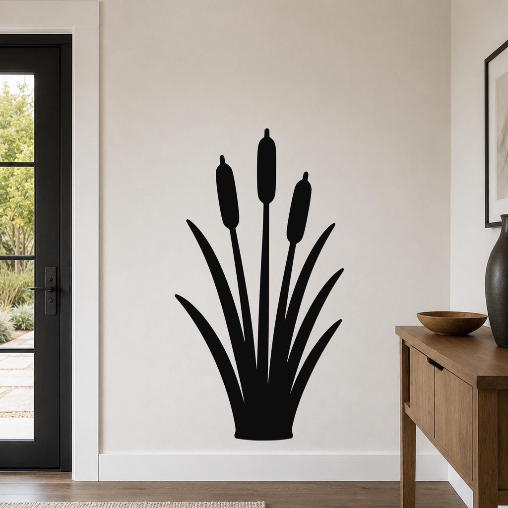 Black metal cattail wall art silhouette with three seed heads and long leaves, mounted on a light-colored wall in a modern entryway.