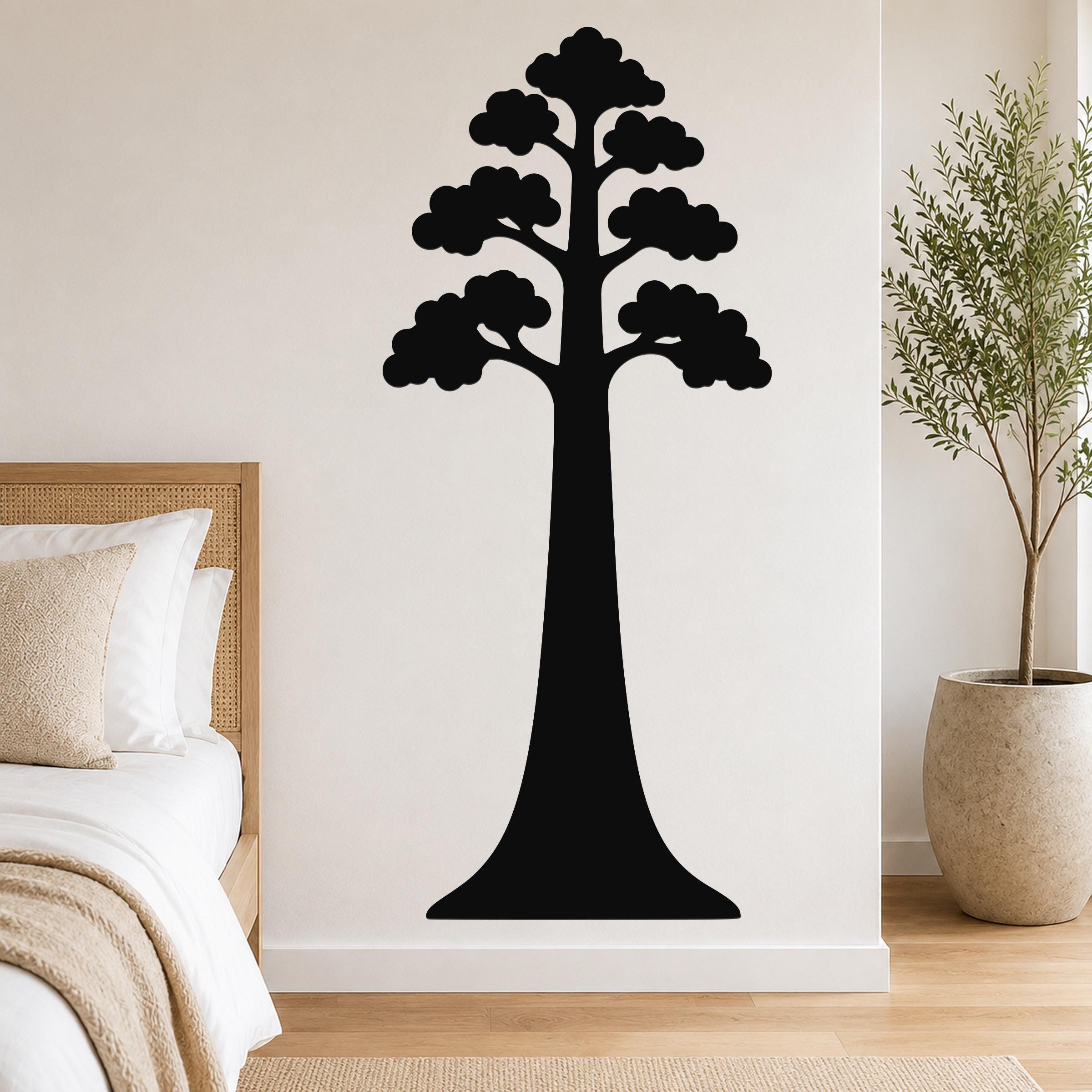 Black metal wall art of a sequoia tree silhouette with layered canopy, mounted on a bedroom wall above a bed.